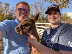 Owners Dirk and Jessie Monson with 2020 cria, Professor Zoom.