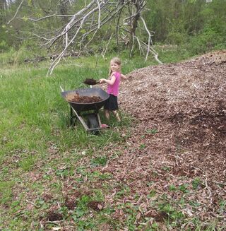 My oldest daughter shoveling woodchips